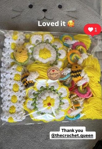 A customer's order of yellow and white crochet flowers, bees and hair ties, still in its packaging